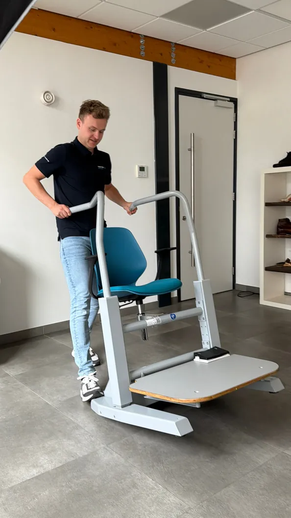 Een voetspecialist die de sta-steunen van de Orthostand M30 verstelt
