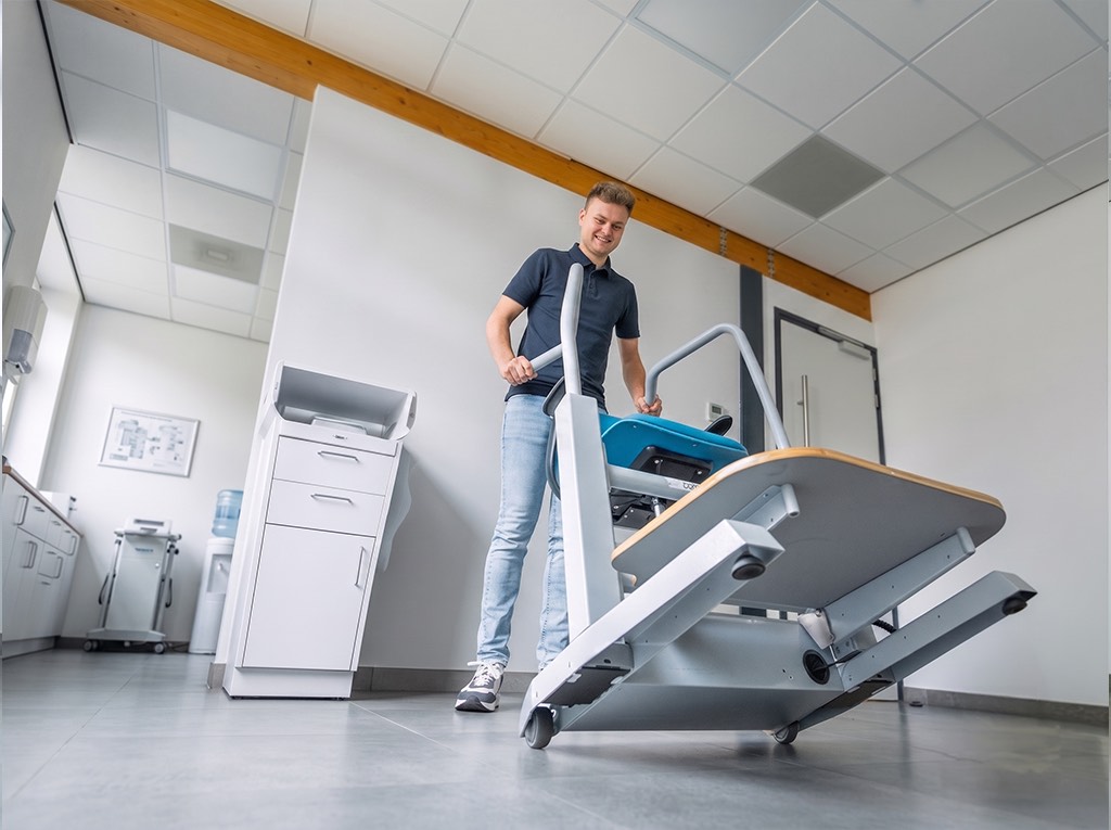 The Orthostand is rolled across the floor on its castors to another part of the room.